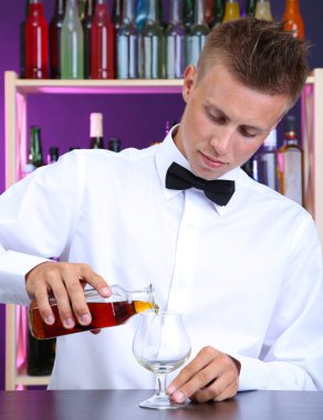 Barmen konyak cam içine yağıyor