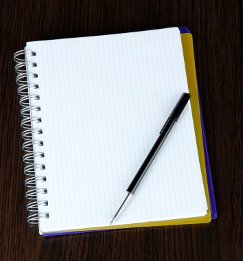 defter ve kalem ahşap masaya