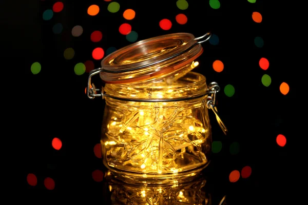 Christmas lights in glass bottle on blur lights background — Stock Photo, Image