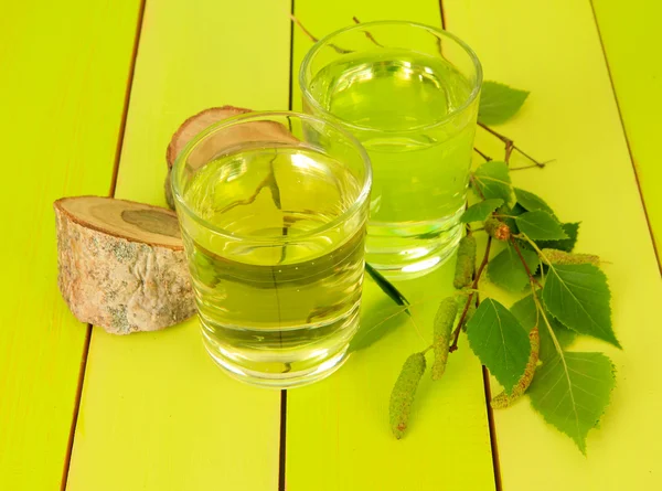 Vasos de savia de abedul sobre mesa de madera verde —  Fotos de Stock