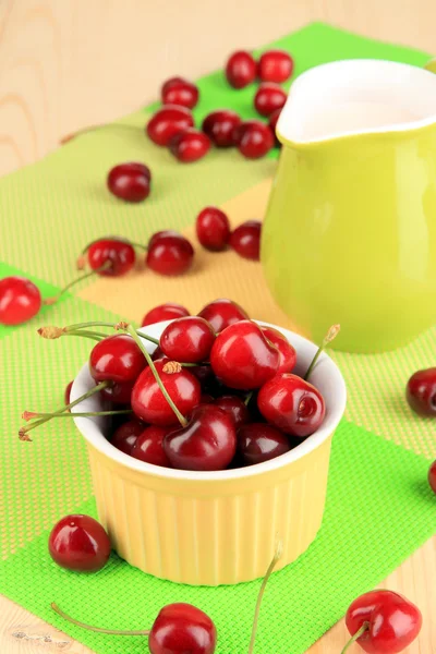 Ripe red cherry berries in bowl on wooden table close-up — Stock Photo, Image