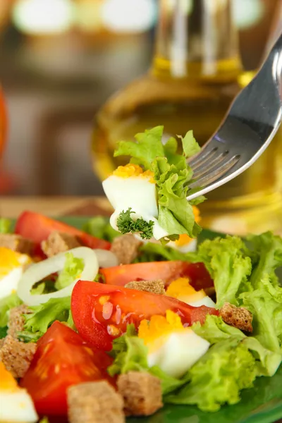Fresh mixed salad with eggs, tomato, salad leaves and other vegetables on color plate, on bright background — Stock Photo, Image