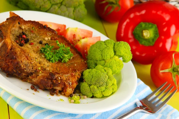 Stekt köttbit på plattan på träbord närbild — Stockfoto