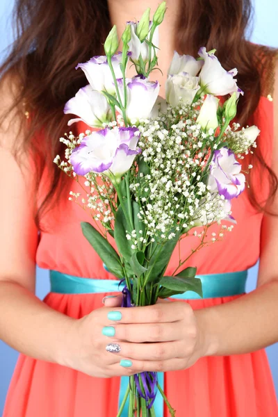 Donna che tiene bouquet, su sfondo blu, primo piano — Foto Stock