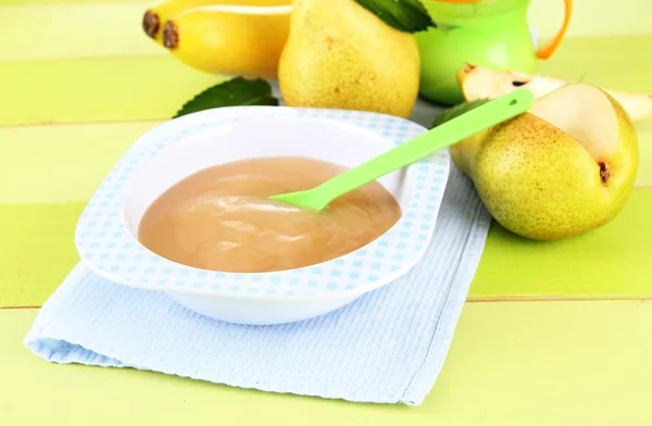 Savoureuse purée de fruits pour bébé et biberon sur table en bois — Photo