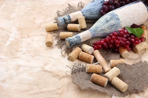 Старые бутылки вина, винограда и пробок на старом бумажном фоне — стоковое фото