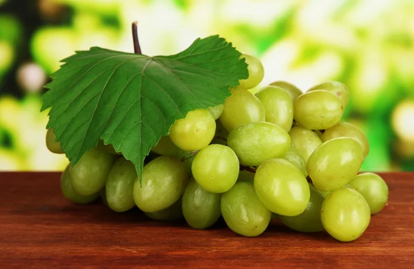 Uvas maduras deliciosas en la mesa sobre fondo brillante — Foto de Stock