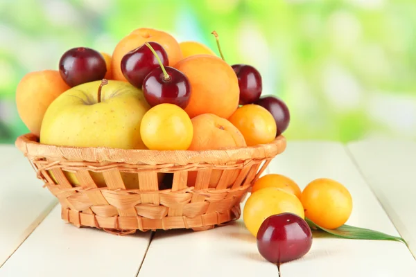 Frutas brillantes de verano en cesta sobre mesa de madera sobre fondo natural —  Fotos de Stock