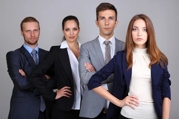 Команда бизнесменов, стоящая в ряд на сером фоне — стоковое фото