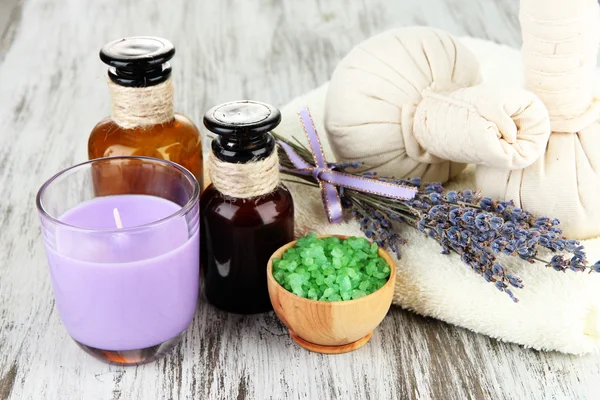 Stilleben med lavendel ljus, tvål, massage bollar, flaskor, tvål och färsk lavendel, på trä bakgrund — Stockfoto