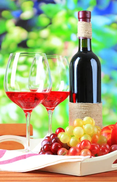 Weingläser auf Serviette auf Tablett auf Holztisch auf Naturhintergrund — Stockfoto