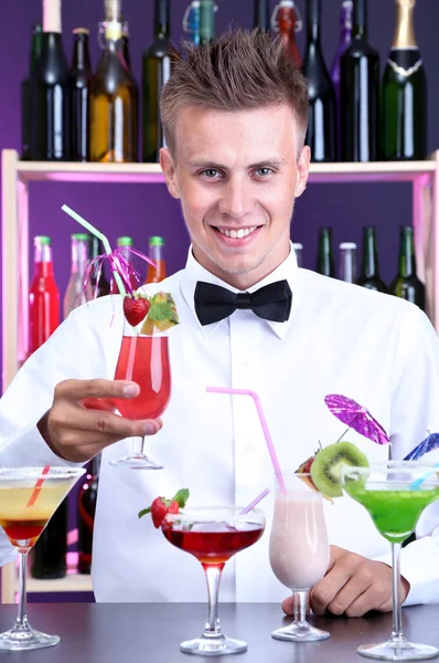 Retrato de barman guapo con cócteles diferentes, en el bar —  Fotos de Stock