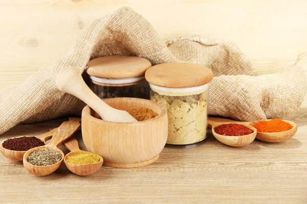 Sortiment av kryddor i träskedar och burkar, på trä bakgrund — Stockfoto