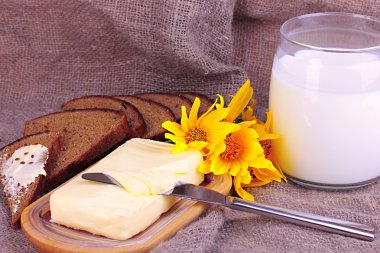 Ahşap kutusunda çevrili arka plan çuval bezi üzerinde süt ve ekmek tereyağı