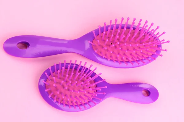 Twee paarse haarborstels op roze achtergrond — Stockfoto