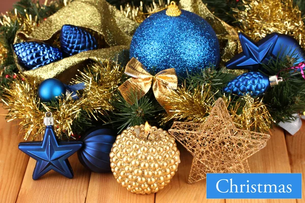 Рождественская композиция со свечами и украшениями в синем и золотом цветах на деревянном фоне — стоковое фото