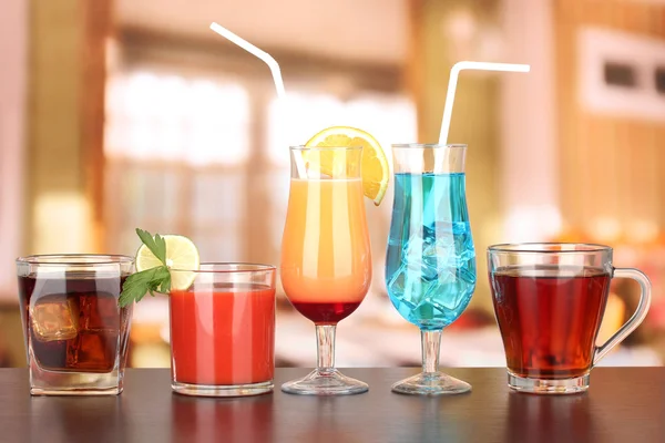 Several glasses of different drinks on bright background — Stock Photo, Image