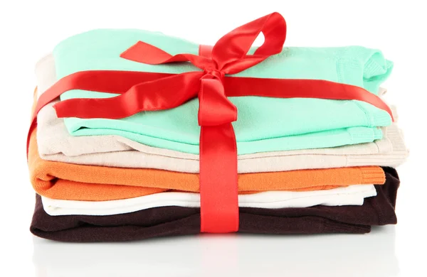 Pile of clothing with red ribbon and bow isolated on white — Stock Photo, Image