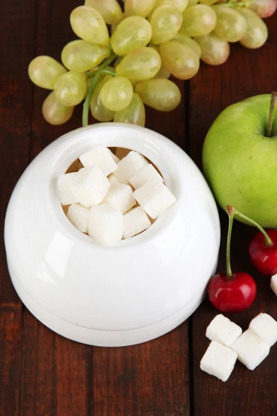 Refined sugar in white sugar bowl on wooden background — Stock Photo, Image