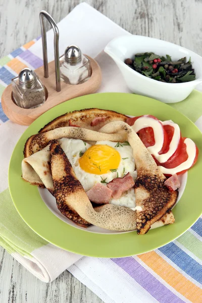 Huevos revueltos y tortitas en plato sobre servilleta sobre mesa de madera —  Fotos de Stock