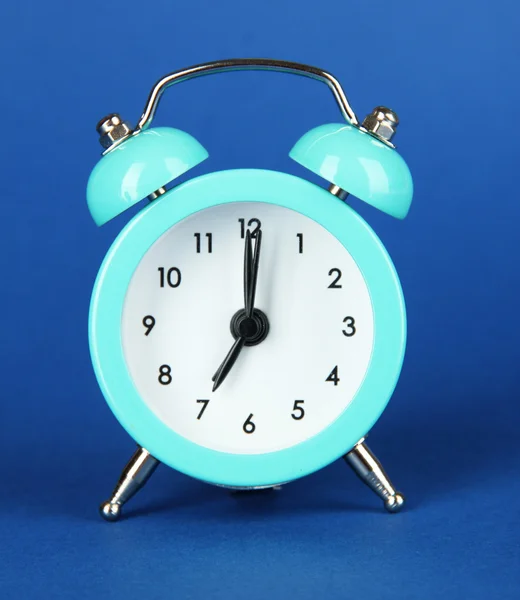 Reloj despertador azul claro sobre fondo azul — Foto de Stock