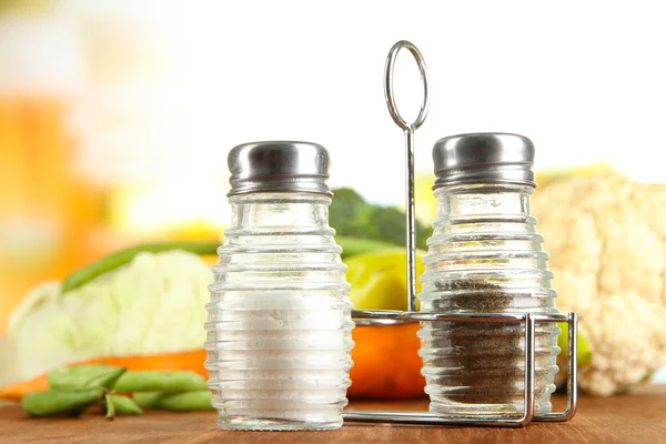 Salt och peppar mal, på träbord, på ljus bakgrund — Stockfoto