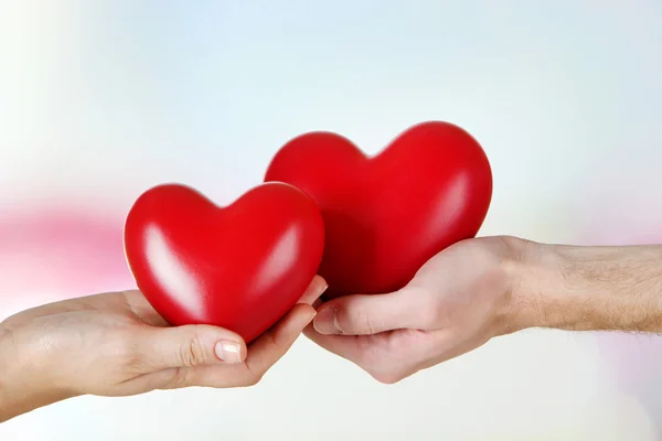 Hearts in hands on light background — Stock Photo, Image