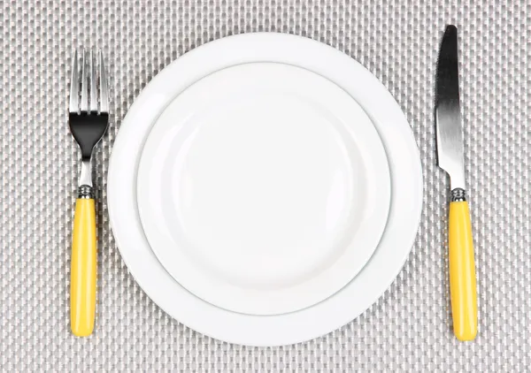 Couteau, plaque de couleur et fourchette, sur fond de couleur — Photo