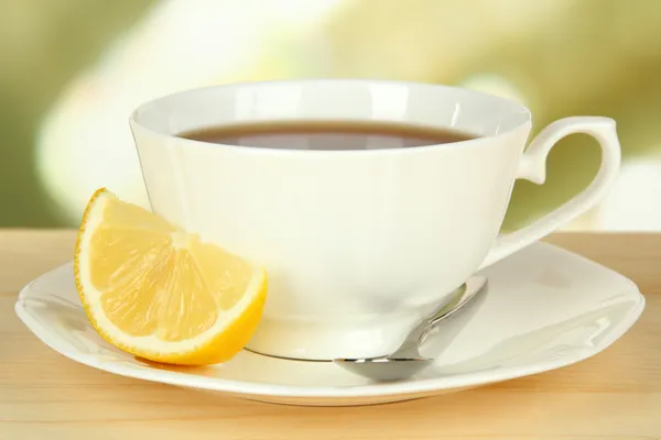 Cup of tea with lemon on table on light background — Stock Photo, Image