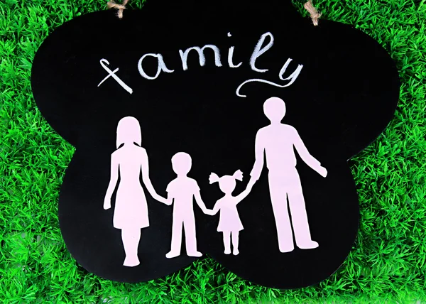 Family from paper on wooden board on bright background — Stock Photo, Image