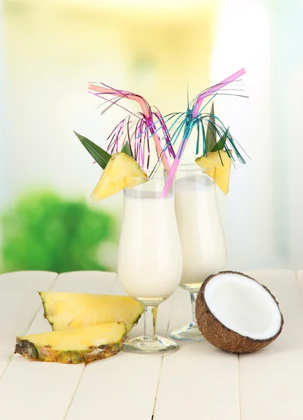 Bebida de piña colada en copas de cóctel, sobre fondo brillante —  Fotos de Stock