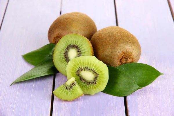 Ripe kiwi on purple wooden table close-up — Stock Photo, Image