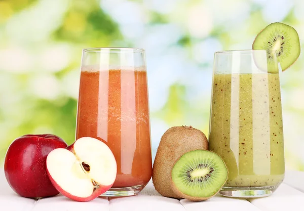 Färska fruktjuicer på träbord, på grön bakgrund — Stockfoto