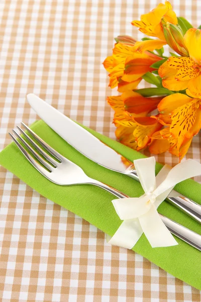 Festliche Tischdekoration mit Blumen auf kariertem Hintergrund — Stockfoto