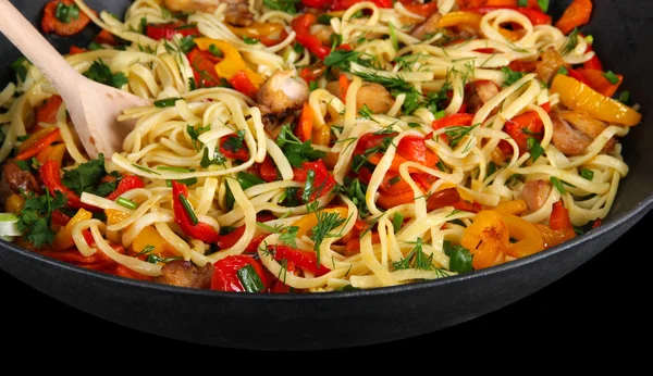 Noodles with vegetables on wok isolated on black — Stock Photo, Image