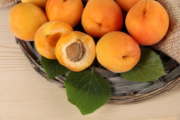 Apricots on wicker coasters on wooden table — Stock Photo, Image