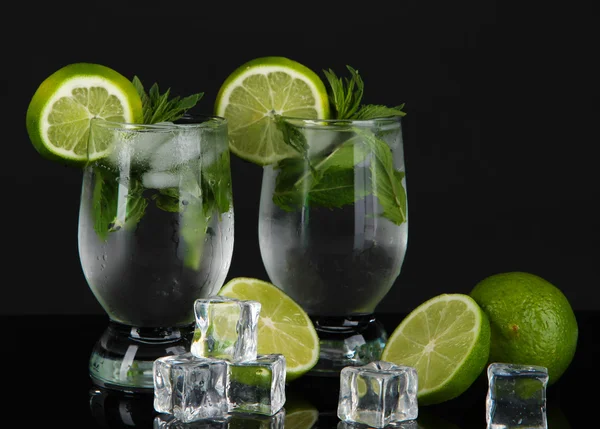 Glasses of cocktail with ice on black background — Stock Photo, Image