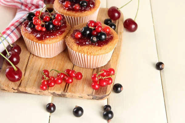 Beyaz ahşap masa üzerinde meyveleri ile lezzetli muffins — Stok fotoğraf