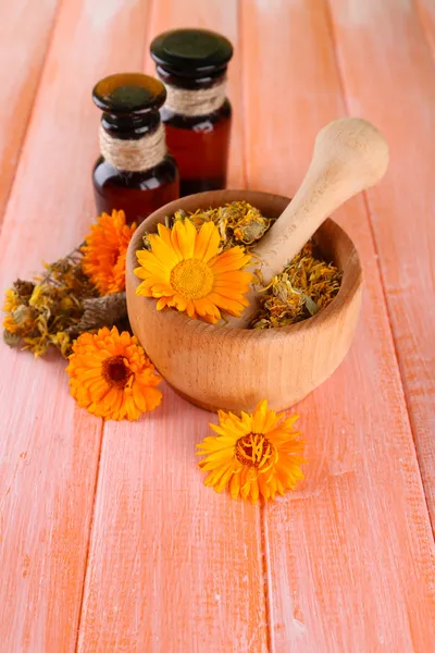 薬のびんおよび木製の背景にキンセンカの花 — ストック写真