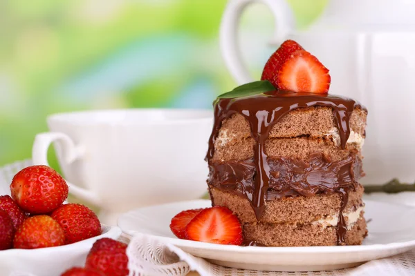 Doğal zemin üzerine ahşap masa üzerinde çilek ile çikolatalı kek — Stok fotoğraf
