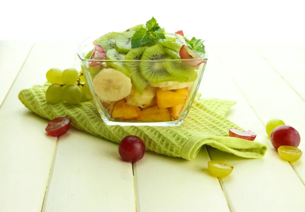 Вкусный фруктовый салат в стеклянной чаше, на белом деревянном столе — стоковое фото