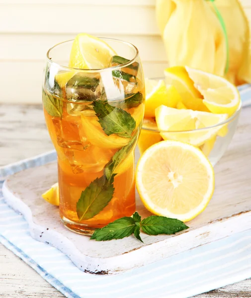 Té helado con limón y menta sobre mesa de madera —  Fotos de Stock