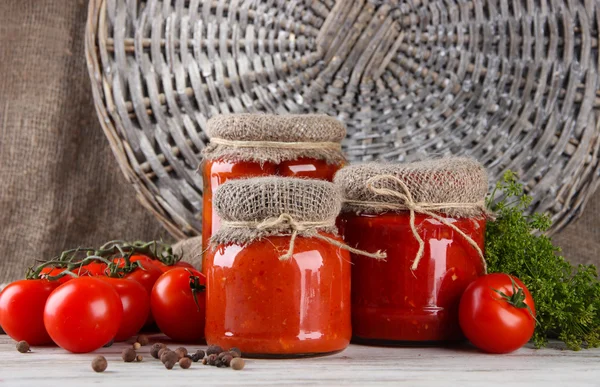 Läckra konserverad och färska tomater på träbord — Stockfoto