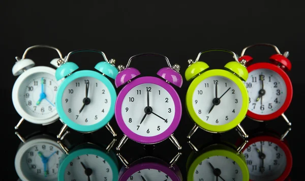 Relógio de alarme colorido no fundo cinza escuro — Fotografia de Stock