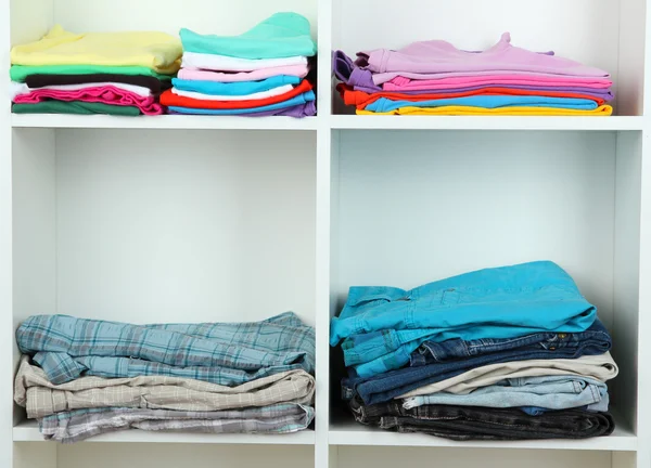 Clothes neatly folded on shelves — Stok fotoğraf