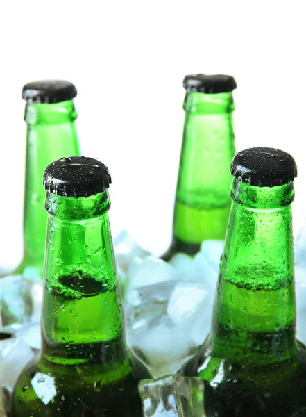 Flessen bier met ijsblokjes, geïsoleerd op wit — Stockfoto