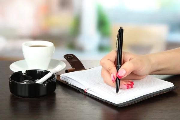 Hand signing in notebook — Stock Photo, Image