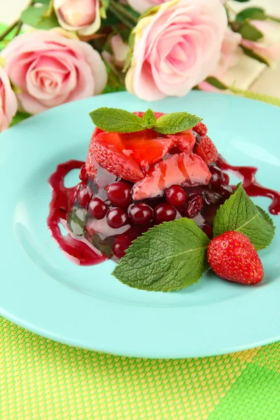 Tasty jelly dessert with fresh berries, on pink roses background — Stock Photo, Image