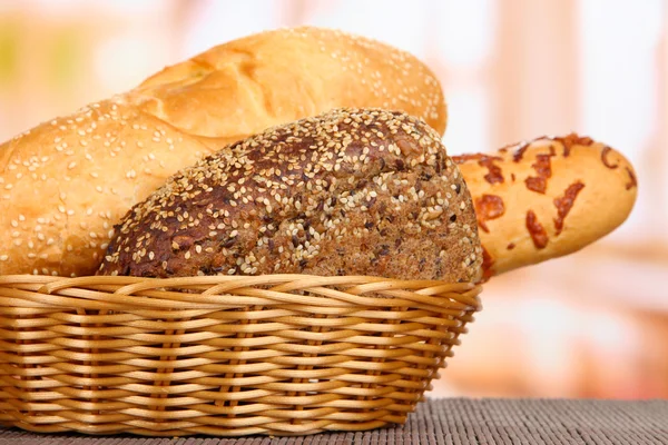 Baked bread in wicker basket on window background — Stock Photo, Image