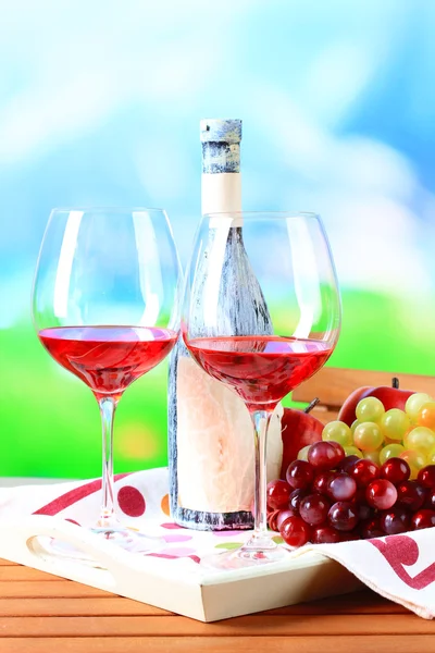 Glasses of wine on napkin on tray on wooden table on nature background — Stock Photo, Image